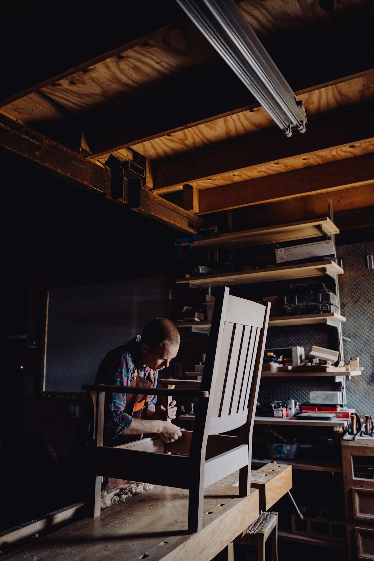 A craftsman hand-building a piece of furniture at the workbench