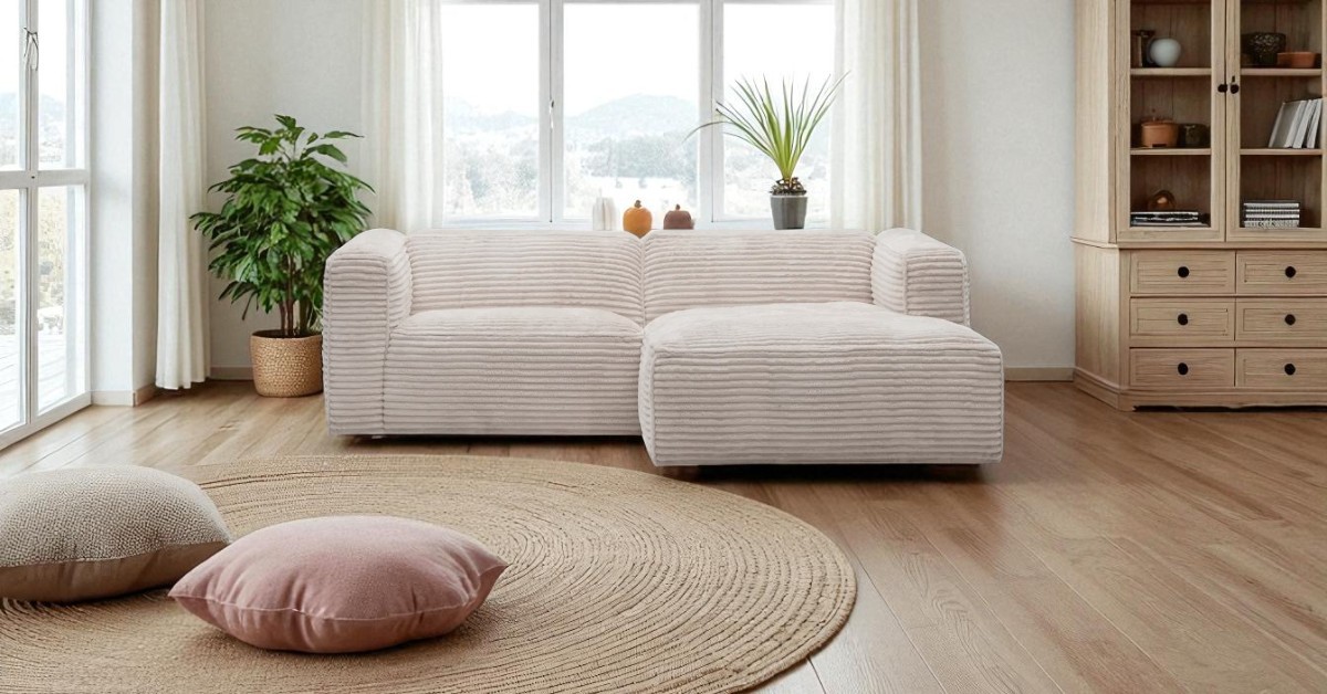 Modern living room with a light beige corner sofa, round woven rug, decorative cushions, indoor plants and wooden furniture, creating a bright and allergy-friendly home interior