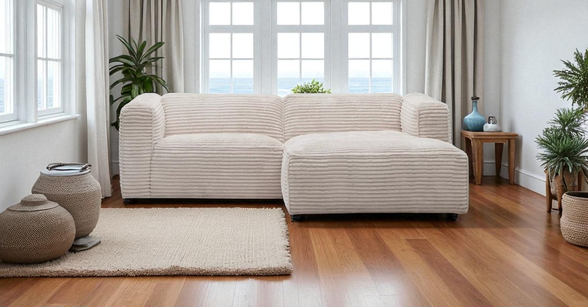 Beige corner sofa in a bright coastal living room with sea view, natural light, woven accents and wooden floor – coastal home furniture care inspiration. Moved Sofa