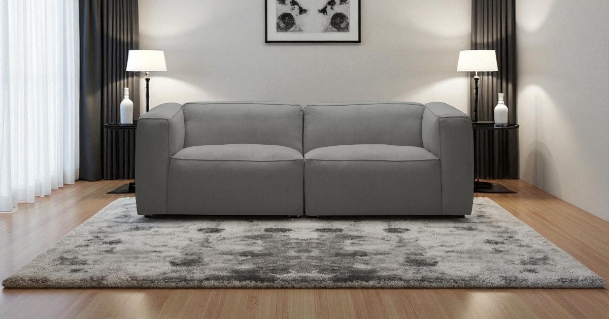 Moved Modern grey sofa styled in a symmetrical living room with matching lamps, artwork and rug – symmetry in interior design inspiration.